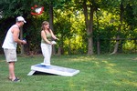Abby attempting to play Cornhole while being distracted by Wes.